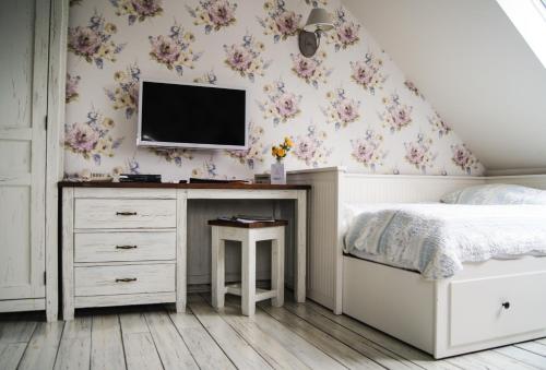 a bedroom with a bed and a tv on the wall at Kalvín Restaurant & Pension in Rastislavice