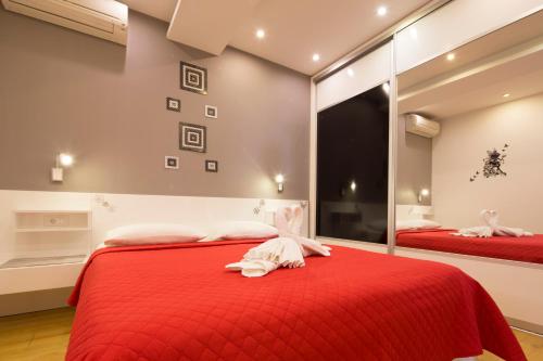 a bedroom with two red beds and a mirror at Villa Nena in Makarska