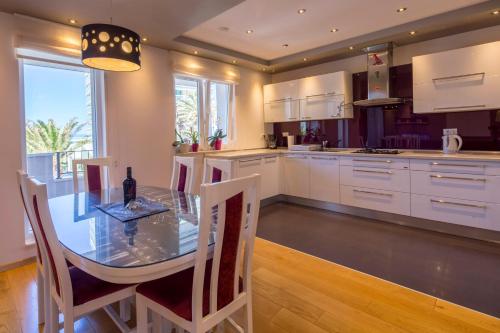 a kitchen with a table and chairs and a kitchen with white cabinets at Villa Nena in Makarska