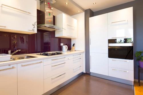 a white kitchen with white cabinets and a sink at Villa Nena in Makarska