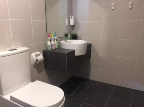 a bathroom with a white toilet and a sink at Damaye Evo Soho Suites in Central Bangi in Kampong Sungai Ramal Dalam