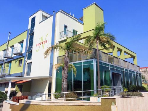 a building with palm trees in front of it at Hotel Nappo in San Marzano sul Sarno