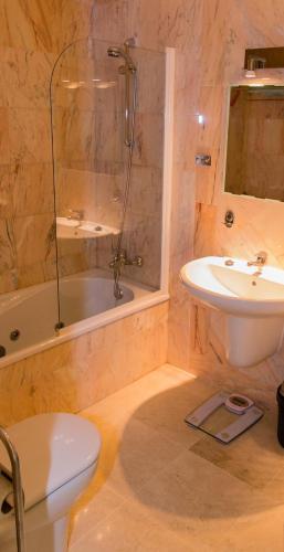 a bathroom with a tub and a sink and a toilet at Luxe Appartement Palm Mar in Palm-Mar