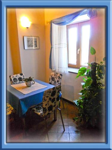 タルクイーニアにあるal castelloのダイニングルーム(テーブル、椅子、窓付)