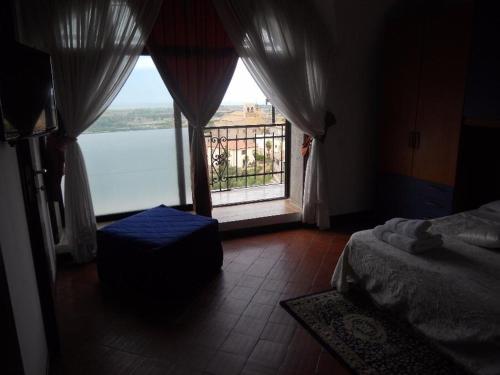 タルクイーニアにあるal castelloのベッドルーム1室(水辺の景色を望む窓付)