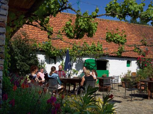 a group of people sitting at a table in a garden at Bladelijn in Lampernisse