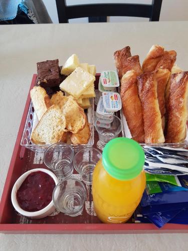 a tray of food with pastries and a bottle of orange juice at Anjana Complejo in Federación