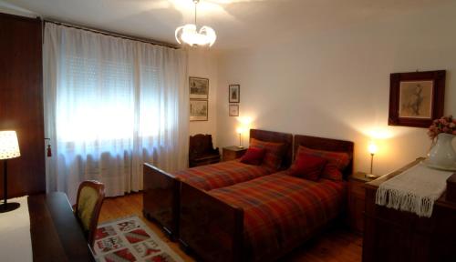 sypialnia z łóżkiem i dużym oknem w obiekcie B&B gil d'o w mieście Bertiolo