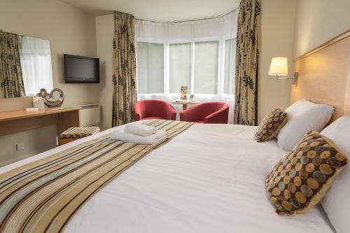 a hotel room with a large bed and a table at Best Western The Dartmouth Hotel, Golf & Spa in Dartmouth