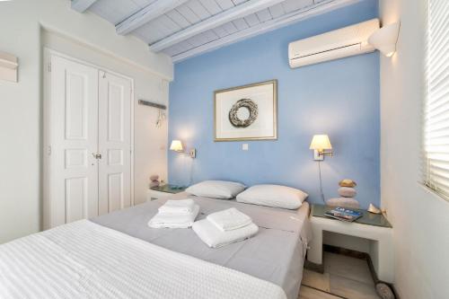 ナウサにあるPURE WHITE 1BD house with amazing Sea Views in Naousaの青いベッドルーム(ベッド2台、デスク付)