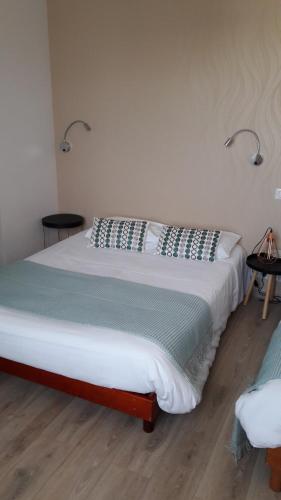 L'Oustal في Naves: سرير في غرفة مع مصباحين على الحائط