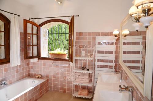 une salle de bain avec une baignoire, un lavabo et un miroir dans l'établissement La Bastide des Pins, à Vence