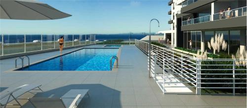 una mujer parada junto a una piscina en un edificio en Costa Horizonte 2, en Concón