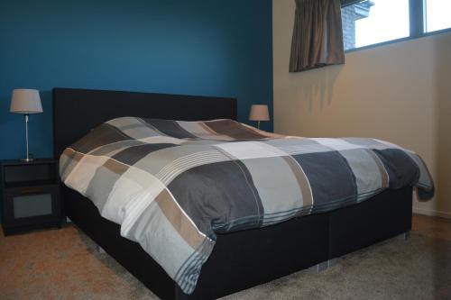 uma cama num quarto com uma parede azul em Appartroom Hasselt em Hasselt