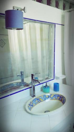 a bathroom with a sink with a mirror and a window at Navegante's House in Almograve