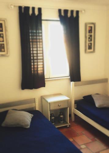 a bedroom with two beds and a window at Navegante's House in Almograve