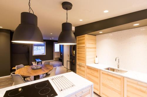 a kitchen with black pendant lights and a table at Acco Luxury Apartments in Akureyri
