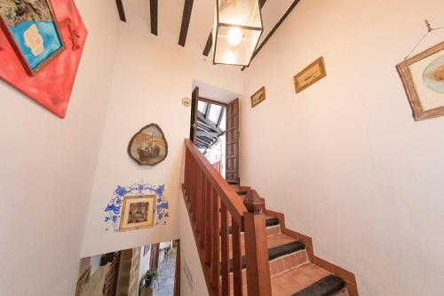 a staircase in a house with paintings on the walls at Palacete Sol de Mayo in Úbeda