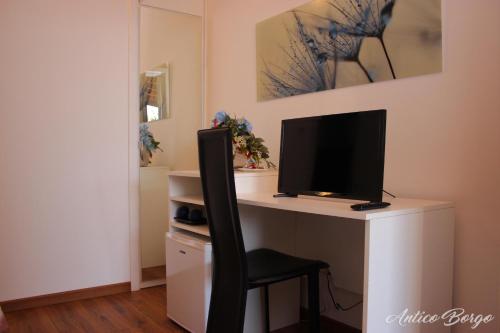 a computer desk with a monitor and a chair at Antico Borgo in San Daniele del Friuli