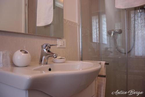 a white bathroom with a sink and a shower at Antico Borgo in San Daniele del Friuli