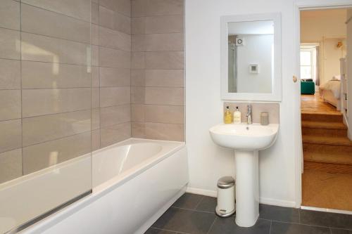 a bathroom with a sink and a bath tub and a toilet at Central Garden Apartment in Brighton & Hove