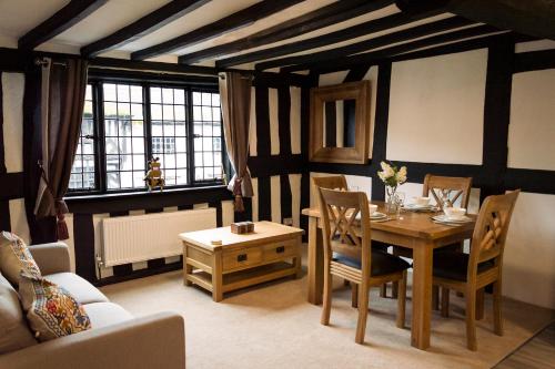 a dining room with a table and a couch and a table and chairs at The Three Gables in Stratford-upon-Avon