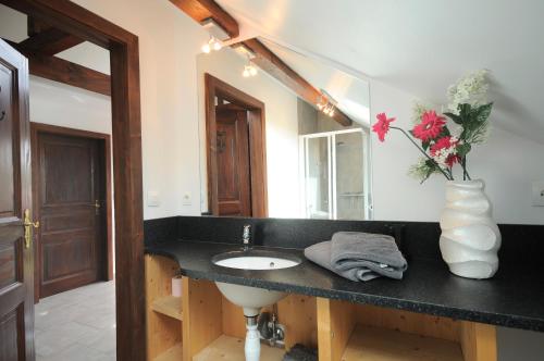 baño con lavabo y jarrón con flores en Gite coté jardin FAHRER ACKERMANN, en Rorschwihr
