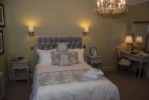 a bedroom with a bed with pillows and a chandelier at Springdale Guest House in Harrogate