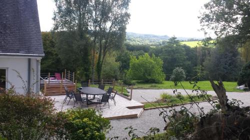 un patio avec une table et des chaises dans une cour dans l'établissement Kerprimel, à Saint-Thois