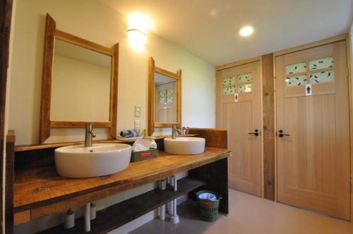 a bathroom with two sinks and a large mirror at Gufo no Mori Kamifurano in Kami-furano