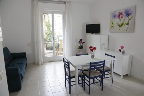 a living room with a table and chairs and a couch at Residence Villa Ofelia in Rimini