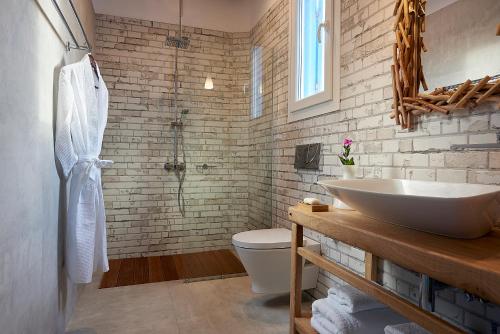 La salle de bains est pourvue d'un lavabo blanc et de toilettes. dans l'établissement Litore Suite, à Pollonia