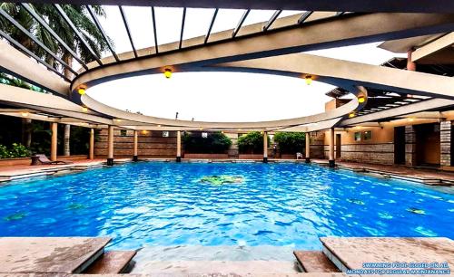 a large swimming pool with a large ceiling at Malligi,Hampi in Hospet