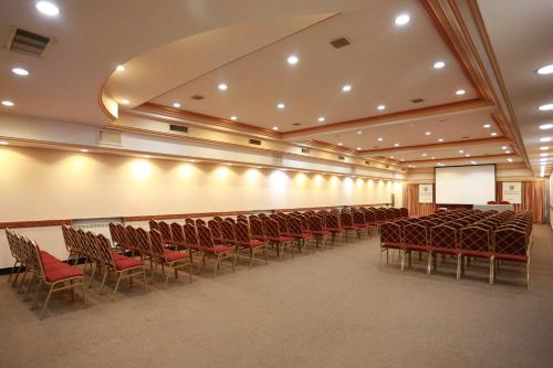 a conference room with chairs and a screen and a podium at Hotel Riogrande in Santa Fe