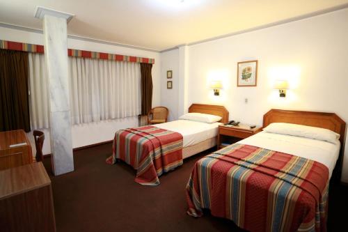 a hotel room with two beds and a desk at Hotel Riogrande in Santa Fe
