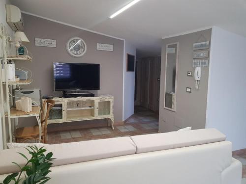 a living room with a white couch and a tv at Appartamento mansardato Anda&Torra in Castelsardo