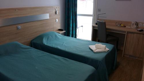 a room with a bed and a desk with a napkin at Les Balcons Du Velay in Monistrol-sur-Loire