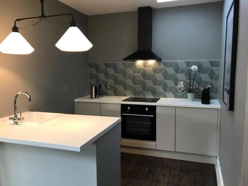 a kitchen with a sink and a stove top oven at Boutique Apartment Ballina Town Centre in Ballina