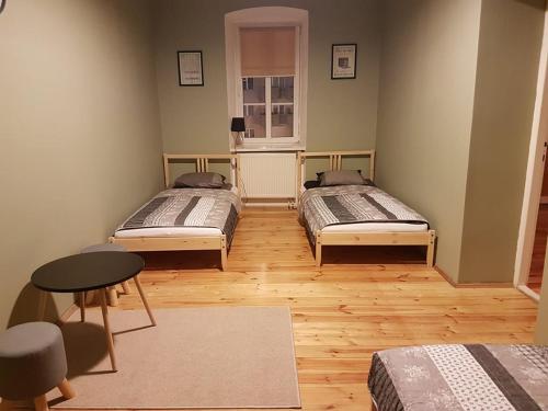 Pokój z 2 łóżkami, stołem i oknem w obiekcie 42-200 Hostel w mieście Częstochowa