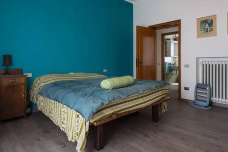 a bedroom with a bed with a blue wall at La Casa di Miele in Perugia