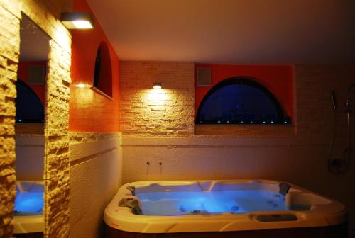 a bath tub in a bathroom with two windows at Villa Castelul Maria in Banpotoc