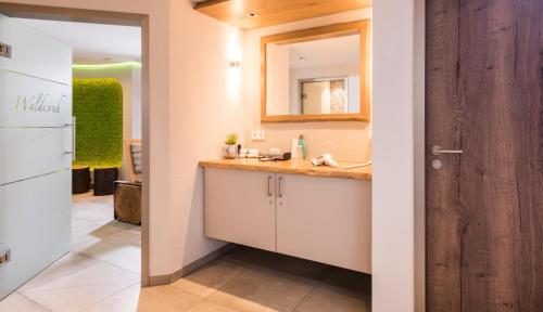La salle de bains est pourvue d'un lavabo et d'un miroir. dans l'établissement Hotel Monika, à Büttelborn