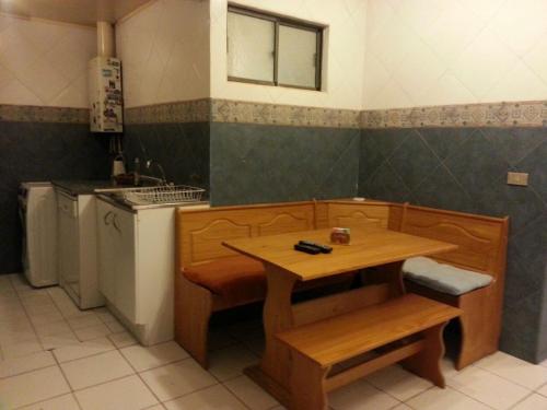 a small kitchen with a table and a sink at Hostal Los Nogales in Coquimbo