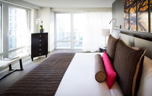 a bedroom with a large bed with pink pillows at Royalton Park Avenue in New York