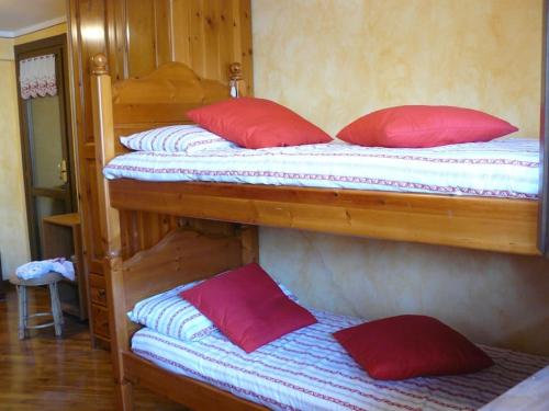 2 Etagenbetten mit roten Kissen in einem Zimmer in der Unterkunft Charme a Cervinia Downtown Ski in-Ski out in Breuil-Cervinia