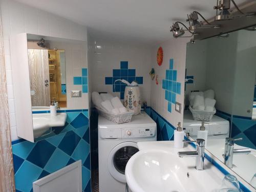 a bathroom with a washing machine and a sink at Appartamento mansardato Anda&Torra in Castelsardo