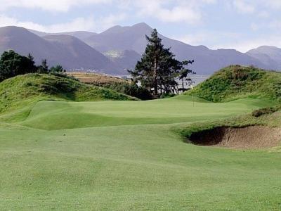 un campo de golf verde con montañas al fondo en Earlscourt en Glenbeigh