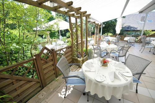 a restaurant with tables and chairs on a patio at Hotel Monika in Büttelborn