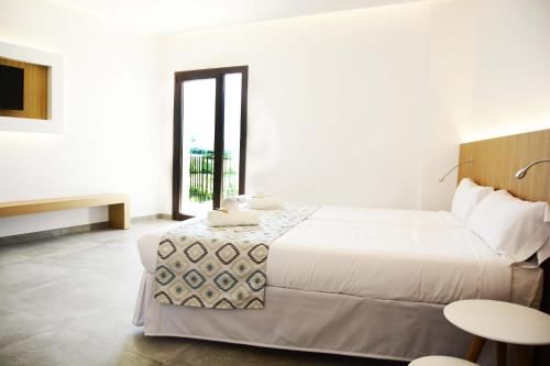 a white bedroom with a bed and a window at Finca Agroturismo Son Menut in Felanitx