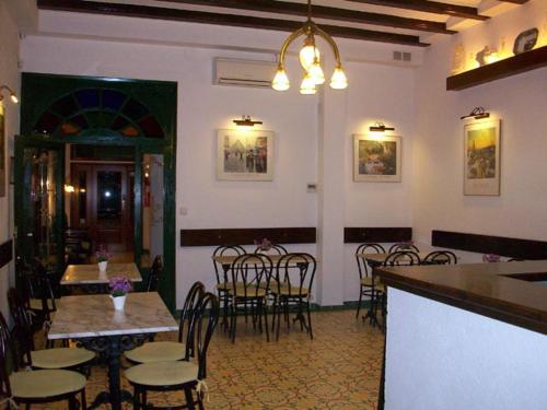 a restaurant with a bar and tables and chairs at Hotel Mitus in Canet de Mar